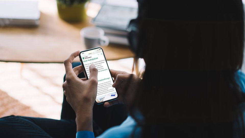 Person hört sich am Smartphone Audiocast an