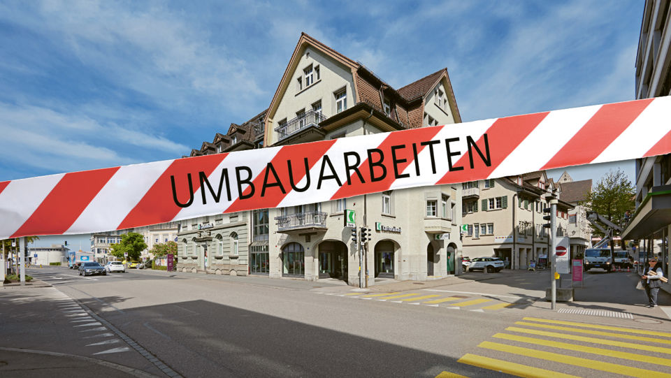 Ansicht vom Gebäude der Niederlassung der St.Galler Kantonalbank in Rapperswil mit einem Band mit Aufschrift "Umbau"
