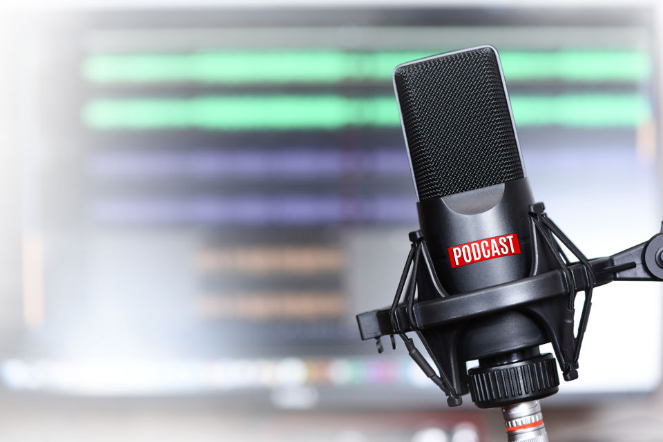 Studiomikrofon mit einer kleinen roten Tafel mit der weissen Aufschrift Podcast
