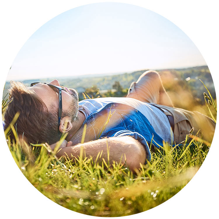Ein Mann liegt mit Sonnenbrille in der Sonne - Sparmethode Happy Day in der Spar-App HäschCash