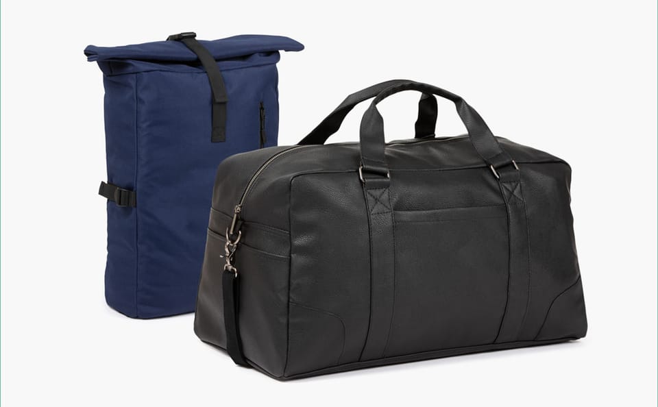 Ein dunkelblauer Rucksack und eine schwarze Reisetasche