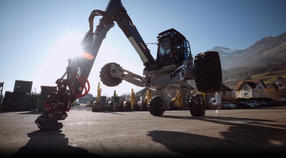 Schreitbagger der Menzi Muck AG hievt sich im Sonnenschein in die Höhe.