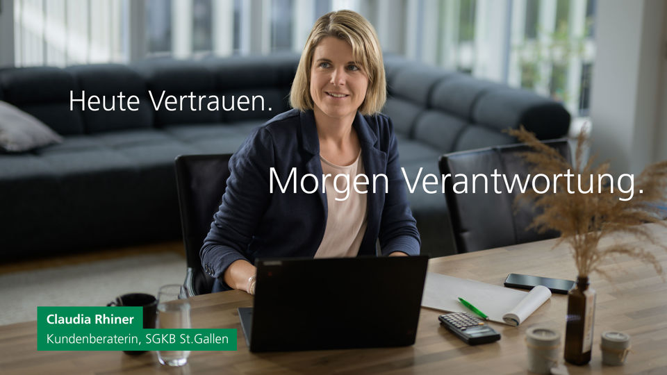 Claudia Rhiner sitzt am Bürotisch mit ihrem Laptop